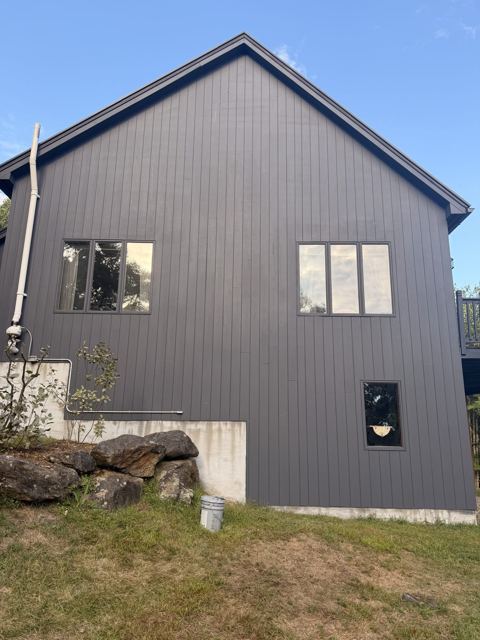Charcoal painted vertical siding on a gabled house