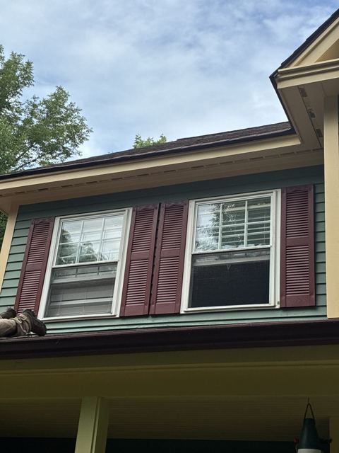 Burgundy shutters and painted trim on a second-story window