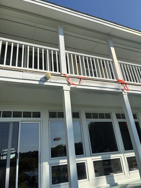 Two-story porch with white railings and trim