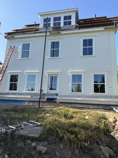 Painted white clapboard siding with trimmed windows